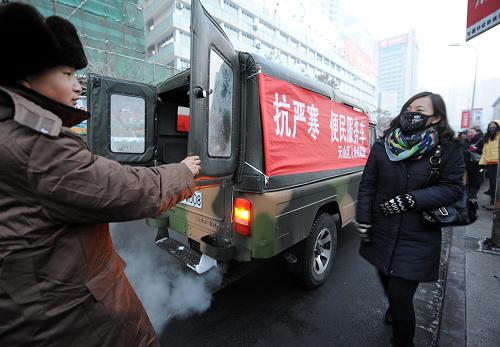 在烏魯木齊市人民廣場公交車站旁,一位女乘客正準(zhǔn)備搭乘天山區(qū)人民武裝部的“抗嚴(yán)寒便民服務(wù)車”回家(1月11日攝)。近期,烏魯木齊市各社區(qū)、公檢法機(jī)關(guān)、民警、武警等多個(gè)部門出動“便民服務(wù)車”,免費(fèi)搭載需要幫助的市民。新華社記者 王菲 攝
