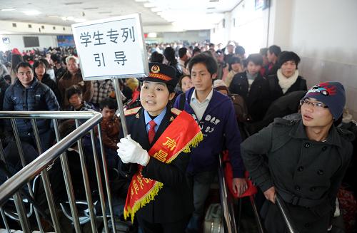 1月12日,南昌火車站一名工作人員手舉指示牌引導(dǎo)學(xué)生進(jìn)站上車。當(dāng)日,南昌火車站開(kāi)出2011年寒假首趟學(xué)生專列。據(jù)南昌火車站工作人員介紹,近期的學(xué)生客流是出行旅客的主要組成部分,南昌火車站將于1月12日至16日開(kāi)行前往贛州、蘭州等方向共計(jì)7趟學(xué)生專列。新華社記者 周科 攝