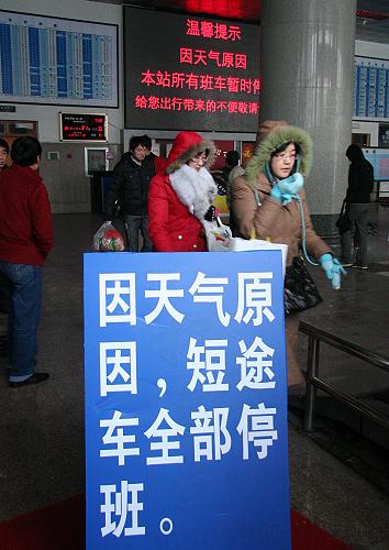 12月31日,在山東威海汽車站,旅客從“短途車停運提示牌”旁走過。新華社發(fā)(于啟波 攝)
