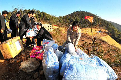 1月23日,楚雄市建設(shè)局工作人員將棉被、衣服和大米等送給重災(zāi)區(qū)西舍路鄉(xiāng)的受災(zāi)群眾。2008年11月,地處哀牢山深處的云南省楚雄彝族自治州楚雄市西舍路鄉(xiāng)等8個(gè)山區(qū)鄉(xiāng)鎮(zhèn)遭遇特大滑坡泥石流災(zāi)害。面對災(zāi)害,楚雄市委、市政府動(dòng)員各級黨政部門領(lǐng)導(dǎo)干部一對一包村到戶,定點(diǎn)扶貧,幫助災(zāi)區(qū)群眾恢復(fù)重建。春節(jié)將至,各部門紛紛組織人員下鄉(xiāng)送溫暖,將越冬和過節(jié)的物品送到受災(zāi)群眾手中。新華社記者陳海寧攝