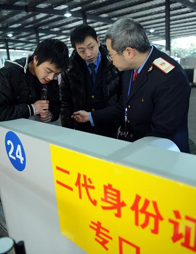 2月14日,重慶火車北站一位工作人員(右)正在解答旅客的提問(wèn)。當(dāng)日是重慶試行火車票實(shí)名制檢票乘車的第一天。重慶火車站、火車北站為了讓旅客順利、快速通過(guò)檢票,專設(shè)了112個(gè)驗(yàn)證口,兩站職工滿員上崗服務(wù)春運(yùn)。新華社記者 周衡義攝