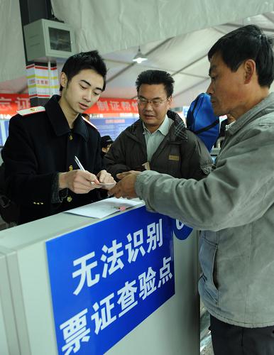 2月14日,重慶火車北站一位工作人員正在為旅客服務(wù)。當(dāng)日是重慶試行火車票實(shí)名制檢票乘車的第一天。重慶火車站、火車北站為了讓旅客順利、快速通過(guò)檢票,專設(shè)了112個(gè)驗(yàn)證口,兩站職工滿員上崗服務(wù)春運(yùn)。新華社記者 周衡義攝