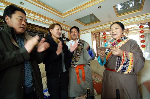 2月14日,青海省西寧市玉樹新村小區(qū)藏族群眾吉格勒家中,女主人吉安(右一)正在唱《祝酒歌》,向客人敬上青稞酒。當(dāng)日是藏歷鐵虎年第一天,高原古城青海省西寧市的藏族群眾沉浸在節(jié)日的歡樂中,他們身著節(jié)日盛裝,探親訪友,互祝新年“扎西德勒”。新華社記者 張宏祥 攝