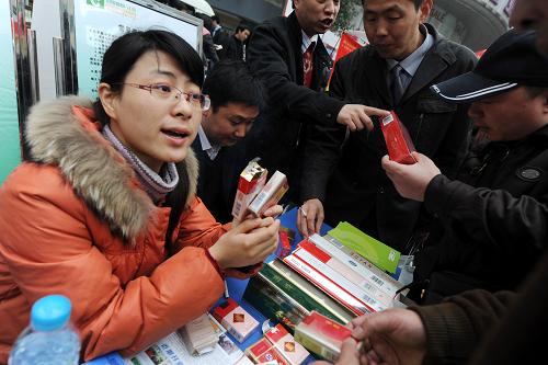 3月14日,南京煙草專賣局的工作人員(左)向市民講解假煙的辨別方法。當日,江蘇省暨南京市工商、質(zhì)監(jiān)、消協(xié)、企業(yè)代表、行業(yè)協(xié)會等相關(guān)部門在南京新街口正洪街廣場聯(lián)合舉行紀念3·15國際消費者權(quán)益日活動。新華社記者 韓瑜慶 攝