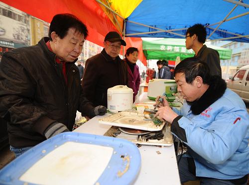 3月14日,一名維修人員(右)在為居民免費維修電磁爐。為迎接“3·15”國際消費者權(quán)益日,山西省消費者協(xié)會、山西省家電維修行業(yè)協(xié)會,在太原市橋南社區(qū)舉辦“家電服務進社區(qū)”活動,由專業(yè)維修人員向居民提供免費維修、免費清洗、免費保養(yǎng)等服務。新華社記者 燕雁 攝