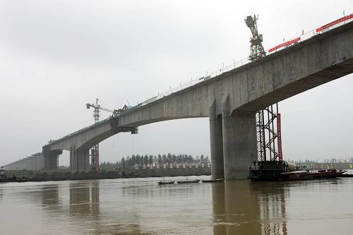 這是8月16日拍攝的建設(shè)中的漢宜鐵路沉湖漢江特大橋。8月16日,國(guó)內(nèi)最大跨度連續(xù)鋼構(gòu)鐵路特大橋——漢宜鐵路沉湖漢江特大橋順利合龍。沉湖漢江特大橋位于湖北省仙桃市境內(nèi),跨越漢江,全長(zhǎng)7.94公里,主跨168米,為(武)漢宜(昌)客運(yùn)專線重點(diǎn)控制工程之一。據(jù)悉,東起漢口站,西接宜昌東站的漢宜鐵路為國(guó)家一級(jí)雙線電氣化鐵路,正線全長(zhǎng)約293公里,于2008年9月動(dòng)工,預(yù)計(jì)2011年底建成。新華社發(fā)(徐云華 攝)