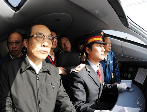 12月3日,鐵道部部長劉志軍(前左)在高速動車組駕駛室監(jiān)控列車運行。新華社記者 陳樹根 攝