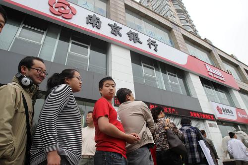 6月16日,市民在江蘇南通一銀行門(mén)口排隊(duì),準(zhǔn)備購(gòu)買(mǎi)中國(guó)共產(chǎn)黨成立90周年普通紀(jì)念幣和2011年賀歲普通紀(jì)念幣。新華社發(fā)(許叢軍 攝)