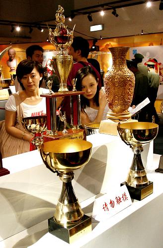 8月21日,觀眾們?cè)谟^看獎(jiǎng)杯。當(dāng)日,“更快、更高、更強(qiáng)——上海體育六十年成就展”在上海舉行。展覽分為“時(shí)光隧道”、“親切關(guān)懷”、“碩果累累的競(jìng)技體育”等七個(gè)章節(jié)。上千幅圖片和近千件珍貴實(shí)物再現(xiàn)了建國(guó)以來(lái)上海體育走過(guò)的不尋常歷程,展示了六十年來(lái)上海體育取得的輝煌成就。 新華社記者 凡軍 攝