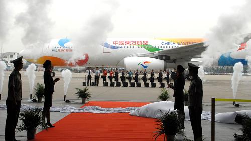 10月12日,東航“世博志愿者號(hào)”彩繪飛機(jī)首航機(jī)組人員準(zhǔn)備登機(jī)。 新華社發(fā)(黃國(guó)慶 攝)