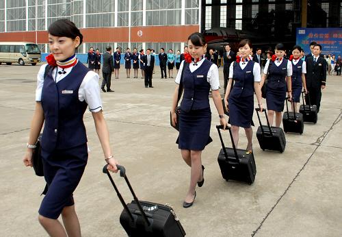 10月12日,東航“世博志愿者號(hào)”彩繪飛機(jī)首航機(jī)組人員準(zhǔn)備登機(jī)。 新華社發(fā)(黃國(guó)慶 攝)
