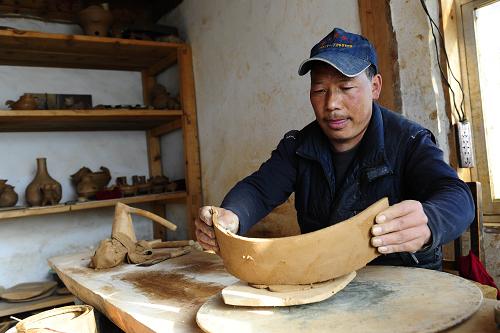 10月21日,云南迪慶藏族自治州香格里拉縣尼西黑土陶有限責任公司工人在打制胚子。新華社記者 任勇 攝