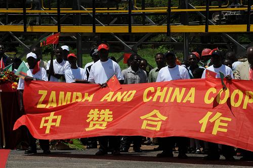 12月22日,在贊比亞盧安夏銅礦的巴魯巴礦區(qū),礦工手舉標語慶祝巴魯巴礦正式恢復生產(chǎn)。 新華社記者 海明威 攝