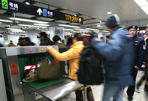 1月4日,在上海地鐵世紀大道站,乘客們將隨身攜帶的物品放入X光檢測儀內(nèi)進行安檢。 新華社發(fā)(范筱明 攝)