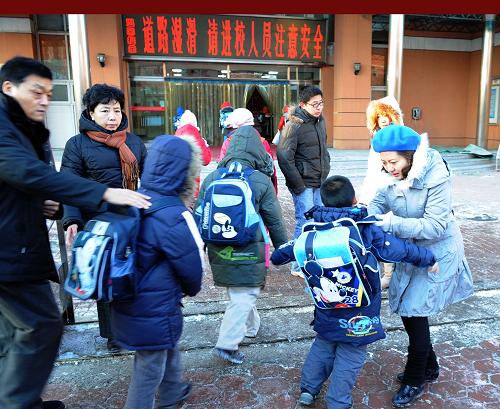 1月5日,學(xué)生家長(zhǎng)將孩子送到學(xué)校門前。當(dāng)日,天津中小學(xué)在大雪后開始恢復(fù)上課。據(jù)了解,由于積雪造成交通不便,很多家長(zhǎng)比往日提前約30分鐘送孩子上學(xué),交通“早高峰”并沒有影響中小學(xué)生按時(shí)上學(xué)。新華社記者 劉海峰 攝