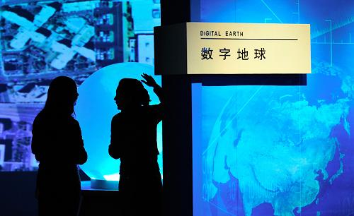 1月12日,兩位體驗(yàn)者在中國(guó)測(cè)繪科技館“數(shù)字地球”廳感受人機(jī)互動(dòng)觸摸球。新華社記者 楊光 攝