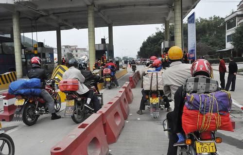 2月3日,返鄉(xiāng)過年的廣西民工騎摩托車準備進入廣東封開縣長崗收費站。 封開縣是321國道從廣東進入廣西的第一站,是廣西籍農(nóng)民工駕摩托車返鄉(xiāng)的必經(jīng)之路。截止到2月3日上午10時,春運以來通過該縣境內(nèi)的返鄉(xiāng)摩托車已超過3.5萬輛(次)。據(jù)初步估計,今年春運期間,通過該縣返鄉(xiāng)和返回珠三角的摩托車將超過13萬輛(次)。新華社發(fā)(韋石明 攝)