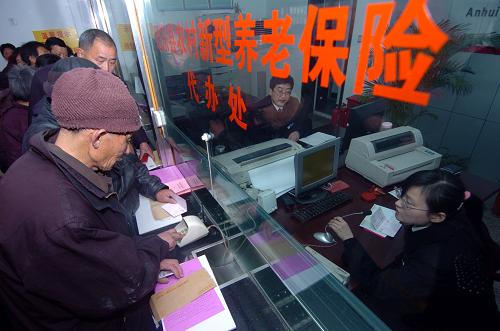 2月8日,在安徽合肥市肥東縣撮鎮(zhèn)農(nóng)村合作銀行內(nèi),農(nóng)民正在憑借新型農(nóng)村社會養(yǎng)老金存折提取保險金。新華社記者 郭晨 攝