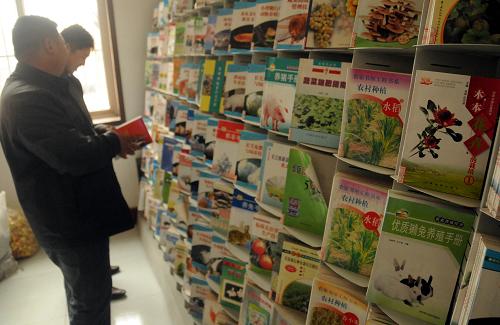 3月18日,在河北省文安縣蘇橋鎮(zhèn)團(tuán)結(jié)村一家商店內(nèi),村民在翻閱店里新農(nóng)民書屋的圖書。新華社記者 鞏志宏 攝