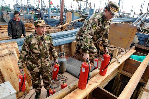 青島營海公安邊防派出所警官上門為漁民送去滅火器具(3月29日攝)。近日,青島公安邊防支隊(duì)在轄區(qū)各漁港內(nèi)開展?jié)O船防火安全專項(xiàng)檢查,對(duì)所有漁船的消防設(shè)施進(jìn)行拉網(wǎng)式檢查,及時(shí)排除存在的火災(zāi)隱患,并對(duì)漁民進(jìn)行滅火技能培訓(xùn),確保春季捕撈高峰作業(yè)安全。新華社記者 李紫恒 攝