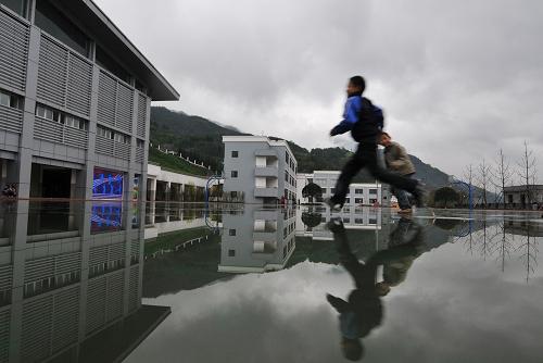 兩位小學生走在雨后的八一水磨小學里(4月12日攝)。新華社記者 江宏景 攝