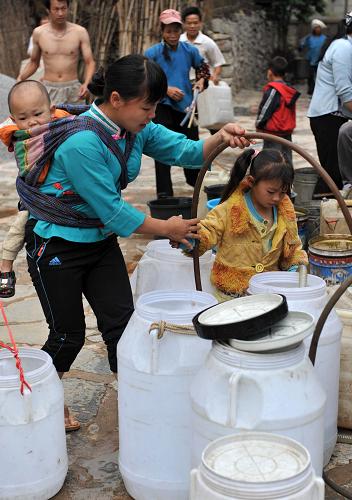 5月23日,在廣西那坡縣城廂鎮(zhèn)龍華村,村民在送水車前忙著接水。新華社記者 周華 攝