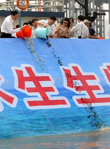 6月6日,活動參與者在向長江放流魚蟹種苗。新華社記者 孫參 攝