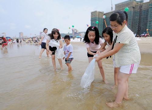 6月6日,幾名小朋友在廣東“休漁放生節(jié)”上放流魚苗。當日,2010南海生物資源增殖放流暨第三屆廣東“休漁放生節(jié)”主題活動在廣東省陽江市海陵島大角灣畔舉行,共放流海水魚苗100萬尾、貝類10噸、海龜200只、鱟200只?;顒悠陂g,中國漁政和公安邊防船只將對放生海域進行巡查,并發(fā)布放生海域禁漁公告。新華社發(fā)(梁文棟 攝)