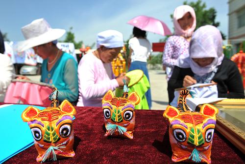 6月12日,寧夏銀川市金鳳區(qū)良田鎮(zhèn)農(nóng)民在展示民間刺繡。當(dāng)日是中國(guó)第五個(gè)“文化遺產(chǎn)日”,寧夏銀川市金鳳區(qū)在轄區(qū)良田鎮(zhèn)舉行“非物質(zhì)文化遺產(chǎn)”進(jìn)鄉(xiāng)村活動(dòng),組織非物質(zhì)文化遺產(chǎn)傳承人、民間藝人為農(nóng)民展示、展演“非遺”項(xiàng)目及傳統(tǒng)民俗作品。新華社記者 王鵬 攝