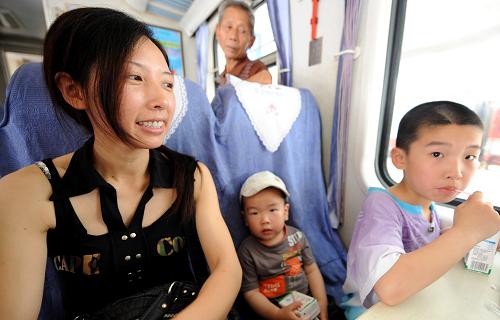 7月1日,一名婦女和孩子乘坐恢復(fù)運營的首趟列車。新華社記者 彭張青 攝