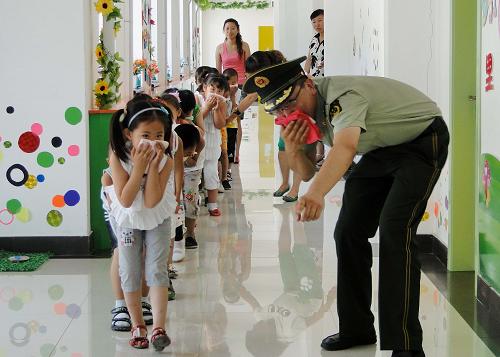 6月30日,新開河公安邊防派出所的民警在組織民族幼兒園的孩子進行火災(zāi)逃生訓(xùn)練。新華社記者 李欣 攝