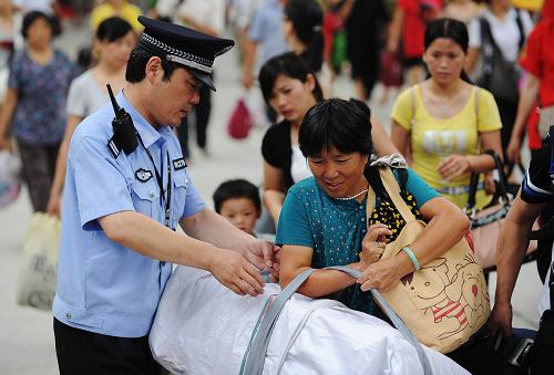 7月1日,合肥火車站派出所一位民警在幫助攜帶大件行李的旅客出站。當(dāng)日,2010年全國鐵路暑運(yùn)工作啟動。根據(jù)鐵道部日前出臺的暑運(yùn)方案,2010年鐵路暑運(yùn)自7月1日起至8月31日止,共62天,預(yù)計(jì)將發(fā)送旅客3.17億人次,日均發(fā)送旅客511萬人次,同比增長8%。新華社記者 李健 攝