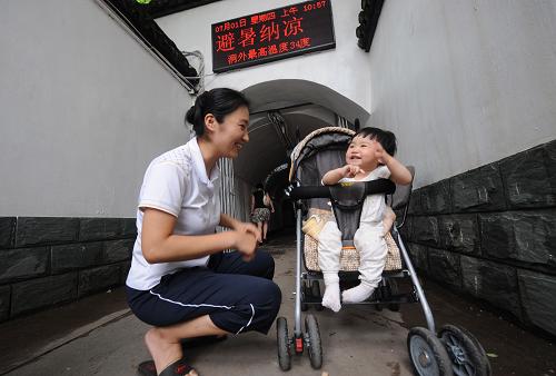 7月1日,10個月大的戴若鑫和媽媽在防空洞口玩耍。新華社記者 韓傳號 攝