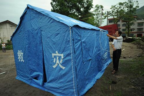 7月9日,工作人員在搭建救災(zāi)帳篷。當(dāng)日凌晨,位于三峽庫(kù)區(qū)的重慶市萬(wàn)州區(qū)分水鎮(zhèn)開始遭受強(qiáng)降雨襲擊,引發(fā)山洪、泥石流、山體滑坡等自然災(zāi)害。強(qiáng)降雨導(dǎo)致大量農(nóng)田被淹、莊稼被毀,分水場(chǎng)鎮(zhèn)及所轄的三正場(chǎng)鎮(zhèn)被淹,積水深達(dá)1.2米。暴雨導(dǎo)致分水鎮(zhèn)6000多間房屋被淹,600多間房屋倒塌,1.5萬(wàn)人受災(zāi)并被緊急安全轉(zhuǎn)移,目前暫無(wú)人員傷亡報(bào)告。新華社記者 周衡義 攝