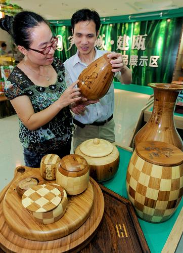 7月9日,游客在福建省建甌市竹產(chǎn)品展示廳參觀竹制工藝品。新華社記者 張國(guó)俊 攝