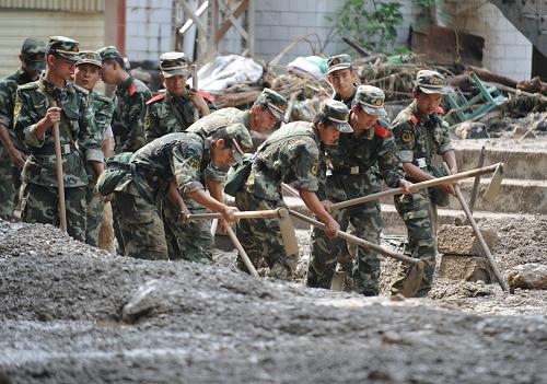 7月14日,武警昭通支隊官兵在巧家縣小河鎮(zhèn)清理街道。新華社記者 秦晴 攝