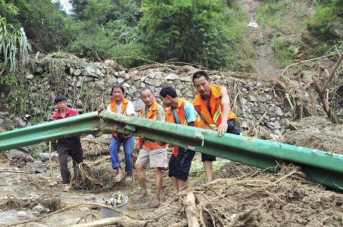 7月24日,宜昌市夷陵區(qū)公路養(yǎng)護工人在搶修被山洪沖毀的公路。新華社發(fā)(張國榮 攝)