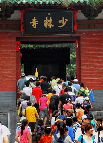 各地游客涌入少林寺山門(7月30日攝)。包括少林寺在內(nèi)的“天地之中”歷史建筑群申報(bào)世界文化遺產(chǎn)成功后,有人擔(dān)心少林寺的門票會(huì)“水漲船高”。對(duì)此,登封市有關(guān)部門和少林寺方面都表示:申遺成功后,不僅少林寺的門票價(jià)格不會(huì)改變,還會(huì)考慮對(duì)“天地之中”歷史建筑群的部分景點(diǎn)實(shí)行免票。新華社記者 王頌 攝
