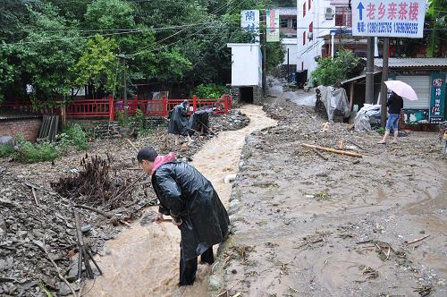 8月19日,一些居民在排水。青川縣城對(duì)岸的東山后某處山體垮塌,順流而下的泥石流將山下排洪渠堵塞,居民們從凌晨4點(diǎn)開始進(jìn)行疏通排水。新華社發(fā)(王生偉 攝)