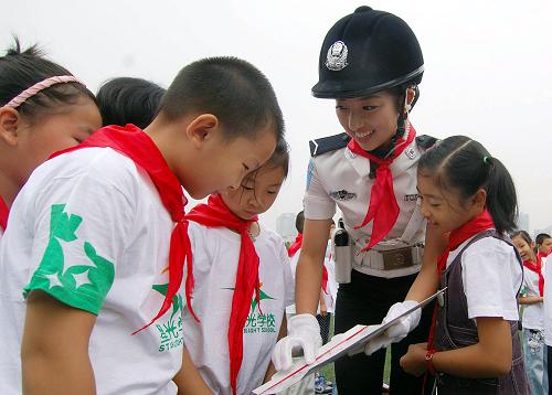9月1日,重慶市女子交巡警總隊(duì)隊(duì)員向星光小學(xué)學(xué)生講解交通安全宣傳畫冊(cè)上的相關(guān)內(nèi)容。新華社記者 陳誠(chéng) 攝