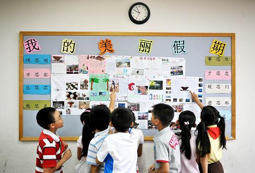 9月1日,在北京第二實(shí)驗(yàn)小學(xué)本校,暑假后重逢的同學(xué)們興致勃勃地欣賞各自制作的假期生活小報(bào)。當(dāng)日,全國(guó)中小學(xué)新學(xué)年開學(xué)。新華社記者 吳曉凌 攝