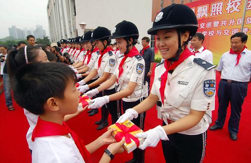 9月1日,重慶市女子交巡警總隊隊員向星光小學(xué)學(xué)生贈送交通安全書籍。當(dāng)日,由重慶市文明辦、共青團(tuán)重慶市委、重慶市教委共同組織的“重慶市中小學(xué)安全文明宣傳月活動”在渝北區(qū)星光小學(xué)正式啟動。來自重慶市女子交巡警總隊的12位女警與1200名同學(xué)共同進(jìn)行了交通安全宣講、交通手勢演練等活動,以增加師生們的交通安全意識,減少交通事故。新華社記者 陳誠 攝