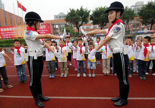9月1日,重慶市女子交巡警總隊隊員向星光小學(xué)學(xué)生示范交通指揮手勢操。新華社記者 陳誠 攝