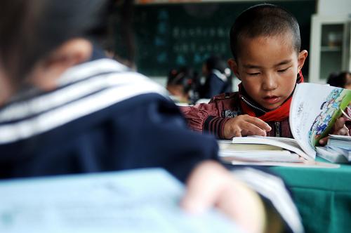 9月1日,在西寧市行知小學(xué)2年級1班,來自玉樹州二完小的更尕江才在翻看自己的新課本。新華社記者 張宏祥 攝