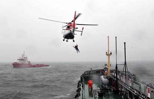 9月7日,救助直升機在“事故”船只上方機降救援人員。新華社記者 朱崢 攝