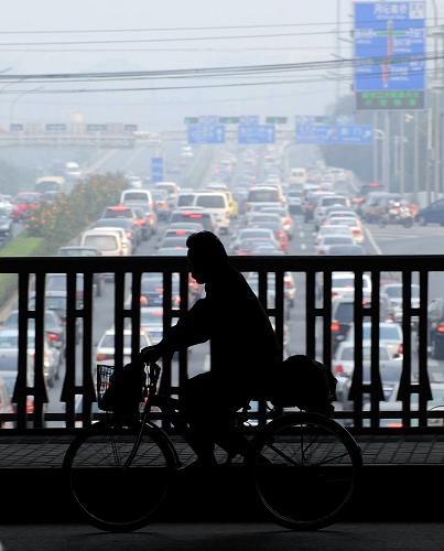 9月25日早高峰時段,一位北京市民騎車從廣安門橋上經(jīng)過。新華社記者 公磊 攝