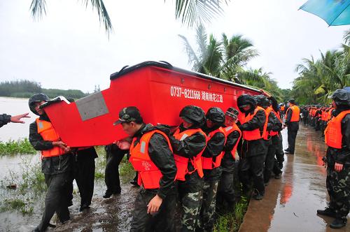 10月7日,海南武警總隊(duì)一支隊(duì)?wèi)?zhàn)士徒手運(yùn)送沖鋒舟至三江水庫(kù)。新華社記者 杜宇 攝