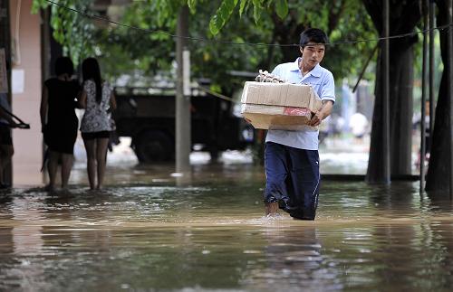10月16日,市民正在瓊海市愛海路的積水中行走。當日,大暴雨再襲瓊島,海南省瓊海市多條主要路段出現(xiàn)嚴重內(nèi)澇,給市民出行造成很大影響。新華社記者 郭程 攝