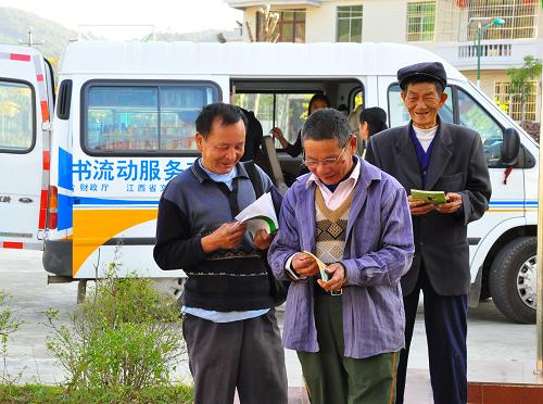 11月9日,江西定南縣圖書館的圖書流動服務(wù)車開進(jìn)龍?zhí)伶?zhèn)鄉(xiāng)村,村民借了圖書就在旁翻看起來。從1986年起,定南縣圖書館自制了13個“流動圖書箱”,將圖書館的圖書在廣大農(nóng)村進(jìn)行循環(huán)供農(nóng)民閱讀。2010年8月,“流動圖書箱”升級為“圖書流動服務(wù)車”,增添圖書1萬余冊,活躍在定南鄉(xiāng)村大地,被鄉(xiāng)村干部群眾譽為“流動圖書館”,深受歡迎。新華社發(fā)(肖榮禎 攝)