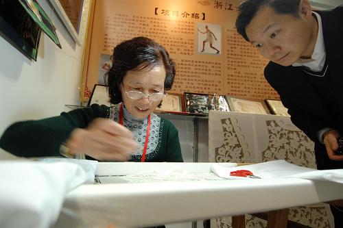 11月11日,一位參觀者在非物質(zhì)文化遺產(chǎn)博覽會上觀看浙江臺州繡衣技藝展示。新華社記者 鞠煥宗 攝